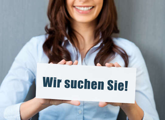 Junge Frau mit einem Schild auf dem "Wir suchen Sie!" steht