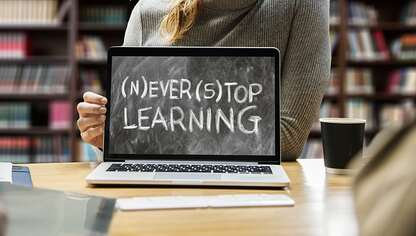 Frau hält Kreidetafel mit der Aufschrift Never Stop Learning