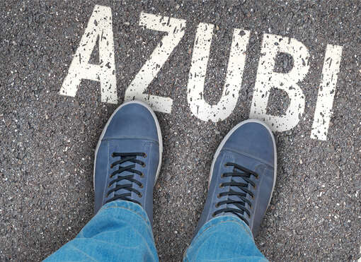 Foto auf die Füße eines Jugendlichen, der auf dem Schriftzug AZUBI steht